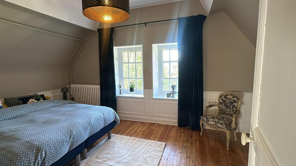 a bedroom with a blue bed and a window at Studio avec vue piscine in Missy-sur-Aisne
