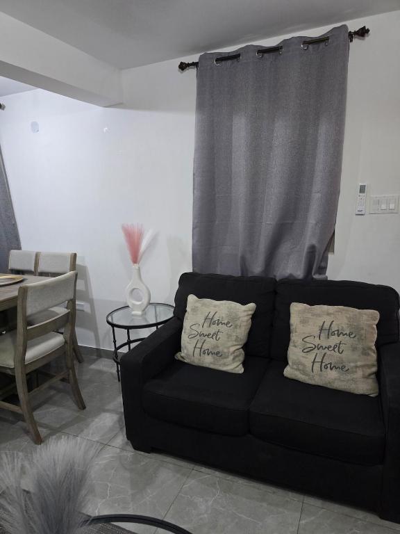 a black couch with two pillows in a living room at Royal's 2 Bedroom suite in Kingston