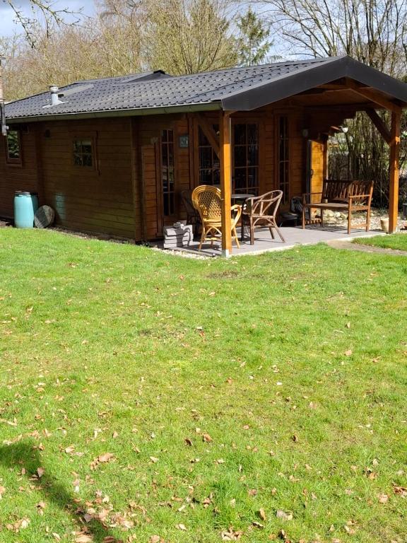 a cabin with a porch with a table and chairs at Blokhut Bron van Rust in Opende