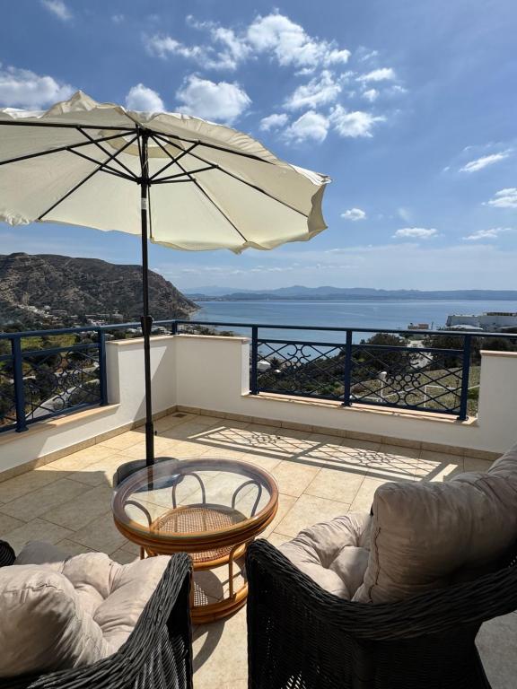 a patio with a table and an umbrella at HillSide Apartments - 02 in Agia Galini