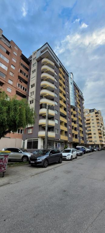 a parking lot with cars parked in front of a large building at Lina Apartment in Bitola