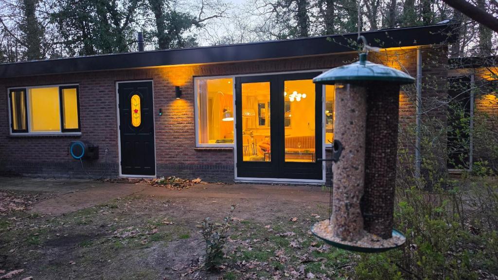 a brick house with a pillar in front of it at Huisje Jan in Hoenderloo