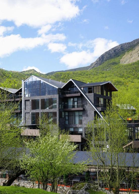 a building with a mountain in the background at Grotto Resort & Restaurant in Quba