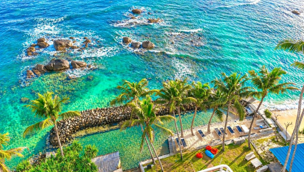 an aerial view of a beach with palm trees and the ocean at LakRaj Heritage in Matara