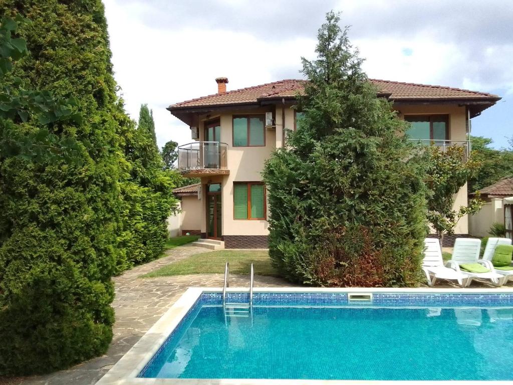 a villa with a swimming pool in front of a house at Вила Зеленка - Villa Zelenka in Bŭlgarevo