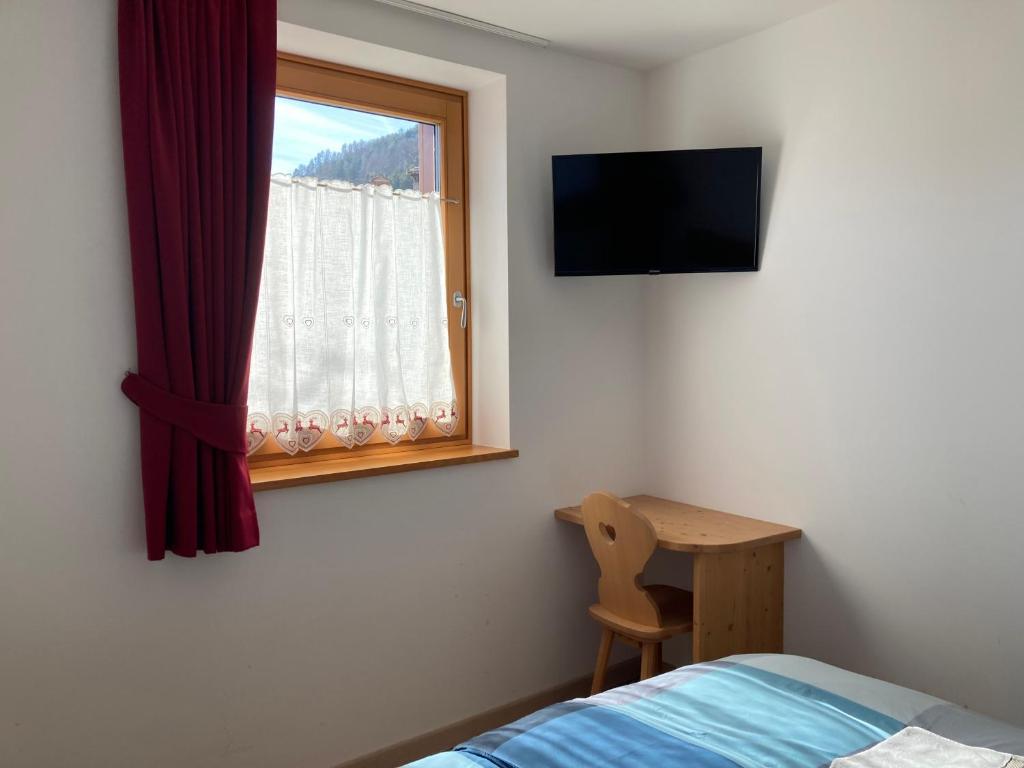 a bedroom with a bed and a window and a desk at Il moleta affittacamere in Balbido-rango