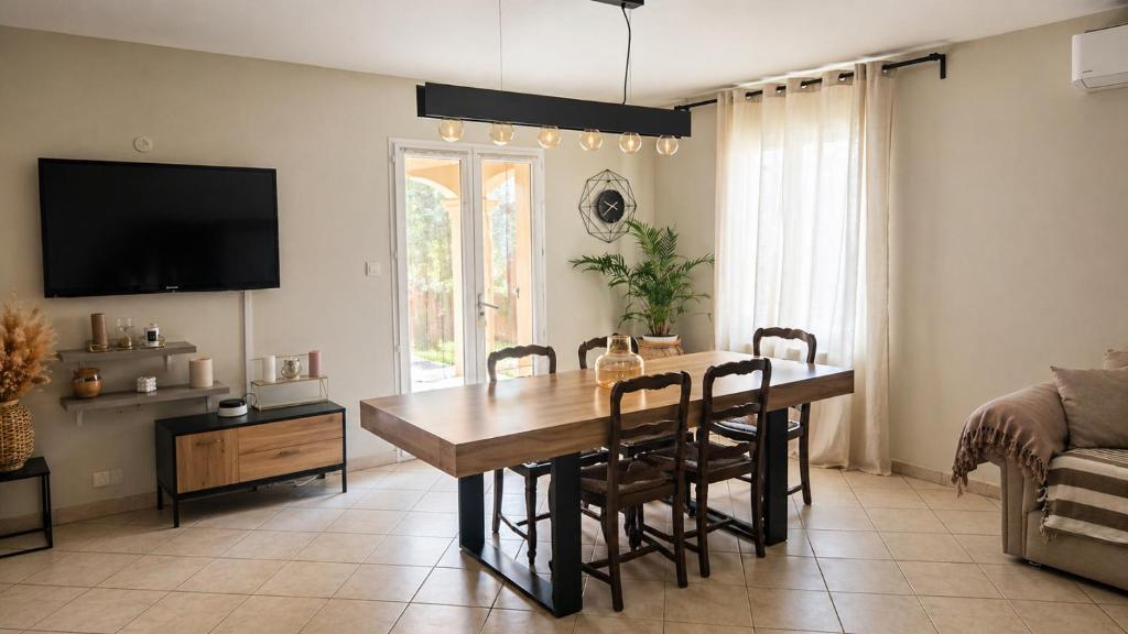 a living room with a dining room table and a couch at PROVENCE, MAISON SPACIEUSE et CONFORTABLE à coté de SPIROU,NARUTO et , WAVE ISLAND in Monteux