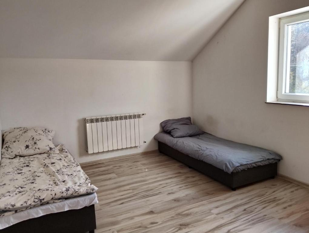 a bedroom with two beds and a window at GM Room in Altanka