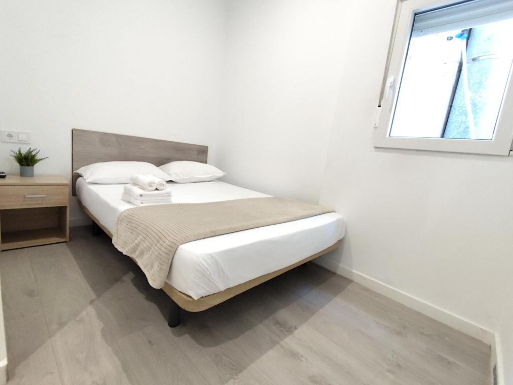 ein kleines Schlafzimmer mit einem Bett und einem Fenster in der Unterkunft Nbm in Puerto de Gandía