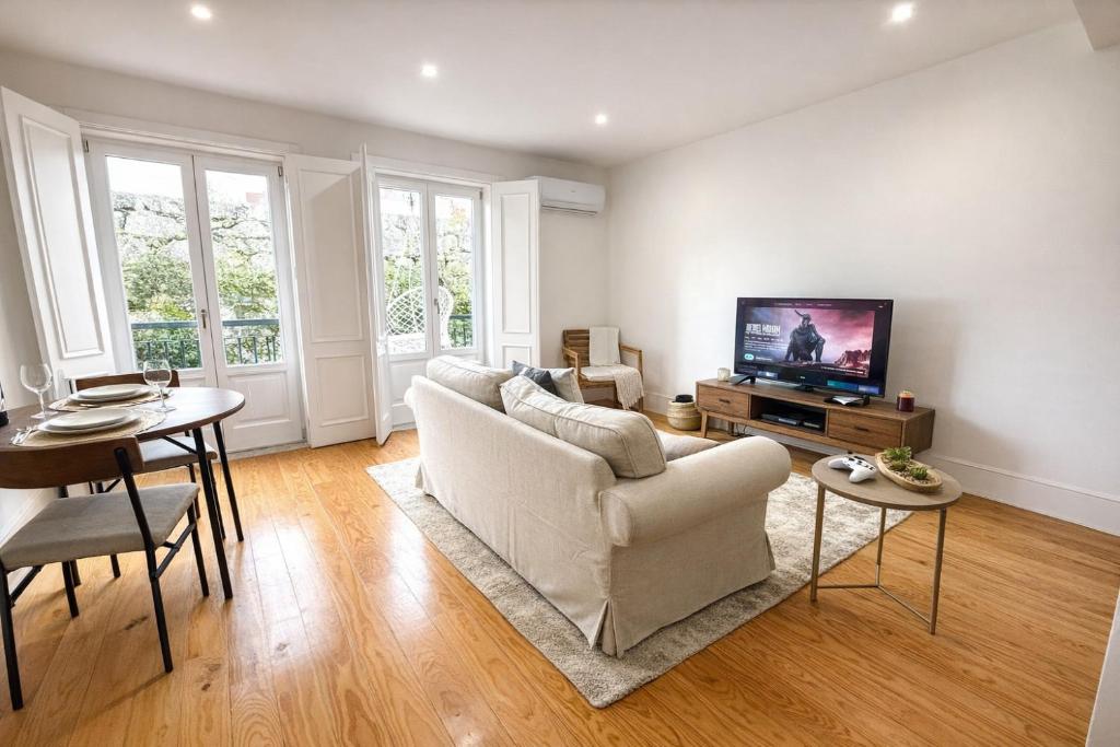 a living room with a couch and a tv at Cc House Porto in Porto