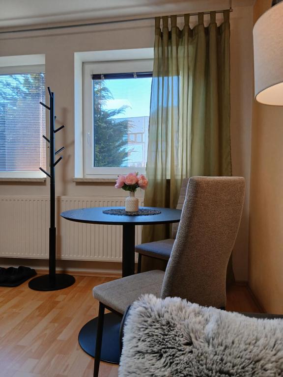 a living room with a table and chairs and a window at Apartments Orange in Uherské Hradiště