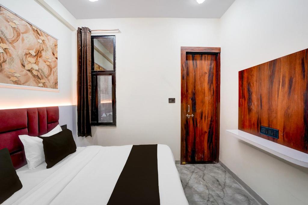 a bedroom with a bed and a wooden door at Hotel O S.P Residency in Indore