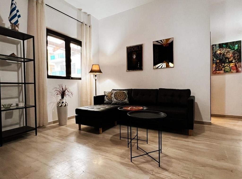 a living room with a black couch and a table at Cozy City Apartment - sleeps 2 in Rhodes Town