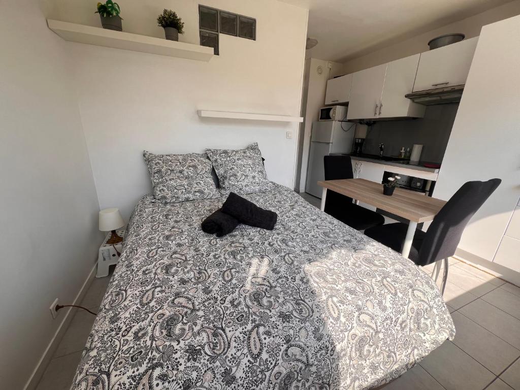 a bedroom with a bed and a table and a kitchen at La Studette Marina 06 in Villeneuve-Loubet