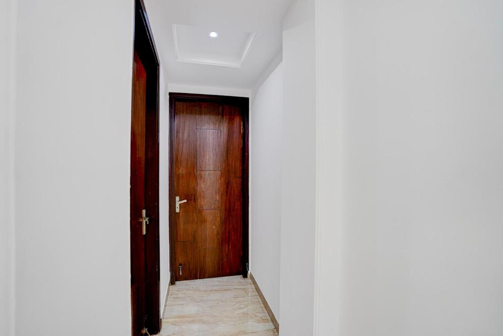 an empty corridor with a wooden door in a room at Hotel O Maxico in New Delhi