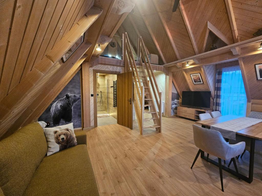 a dog sitting on a couch in a tiny house at Apartamenty SKUPNIOWY UPŁAZ in Murzasichle