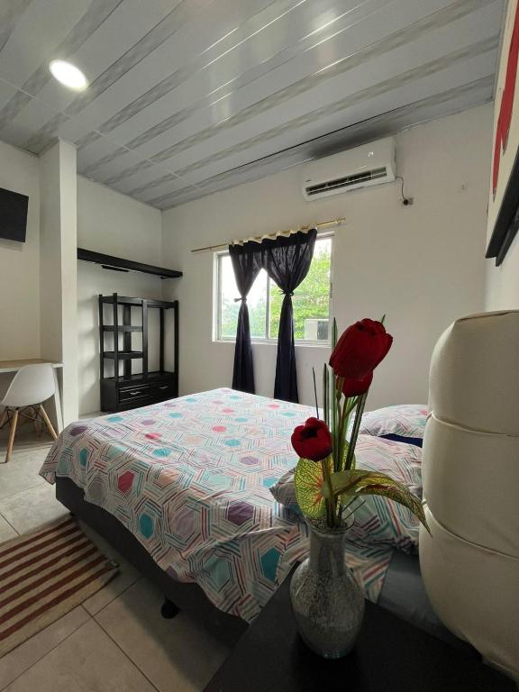 a bedroom with a bed and a window with red roses at 301ElBunkerSuiteRomance in Arauca