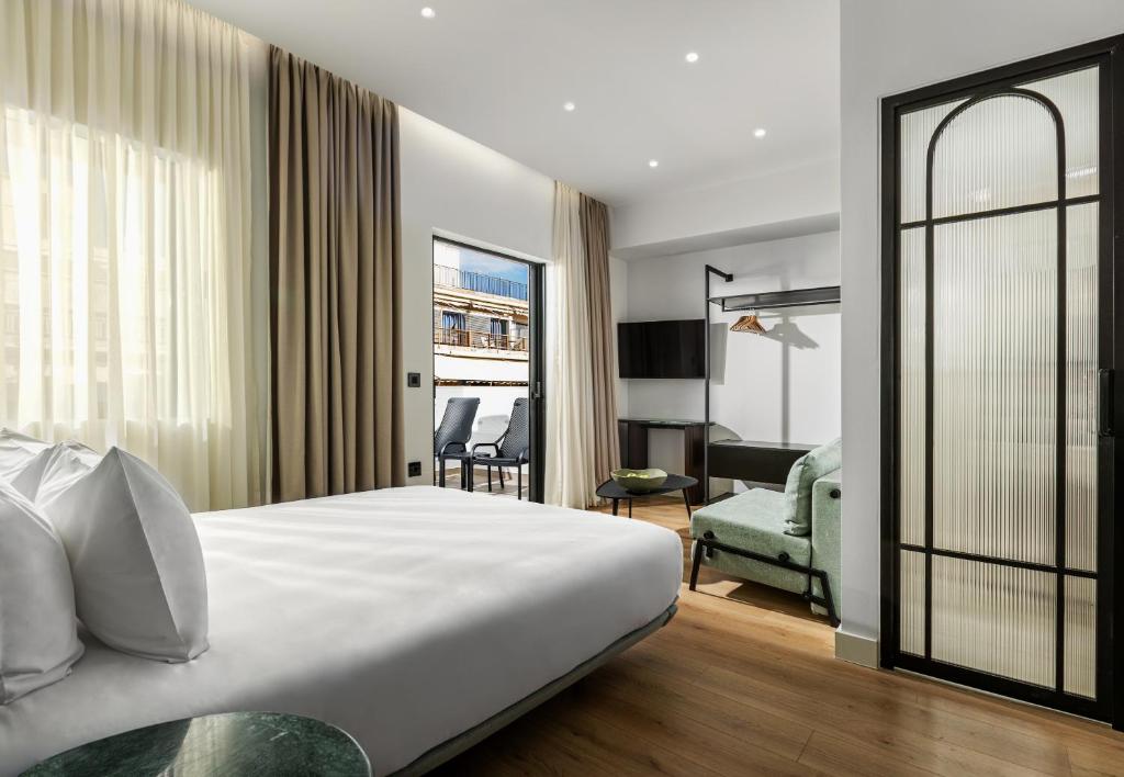 a hotel room with a bed and a chair at Zea Urban Living in Piraeus