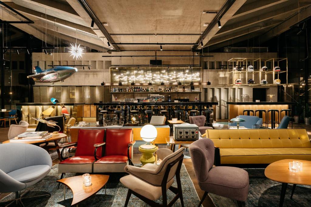 a restaurant with couches and tables and chairs at Ruby Luna Hotel Dusseldorf by IHG in Düsseldorf