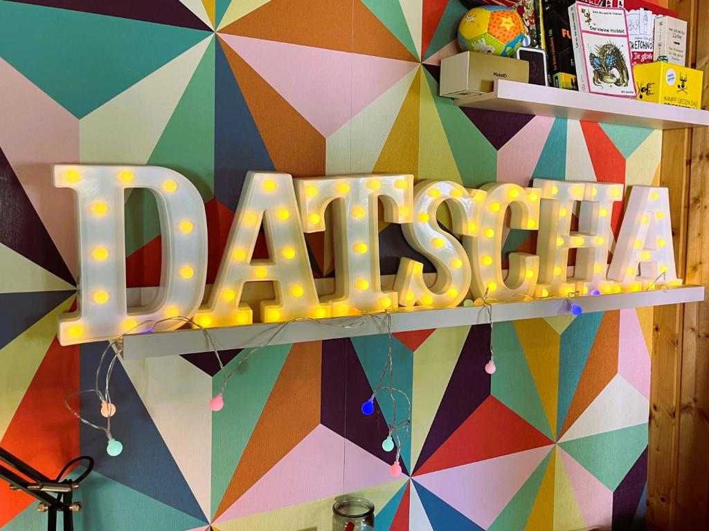 eine bunte Wand mit einem Schild, auf dem „Rave“ steht in der Unterkunft Datscha in Eutin