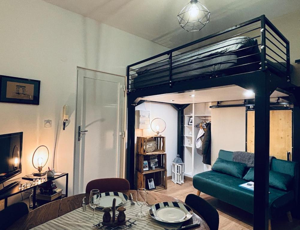 a living room with a green couch and a bunk bed at Chouett'studio in Dijon