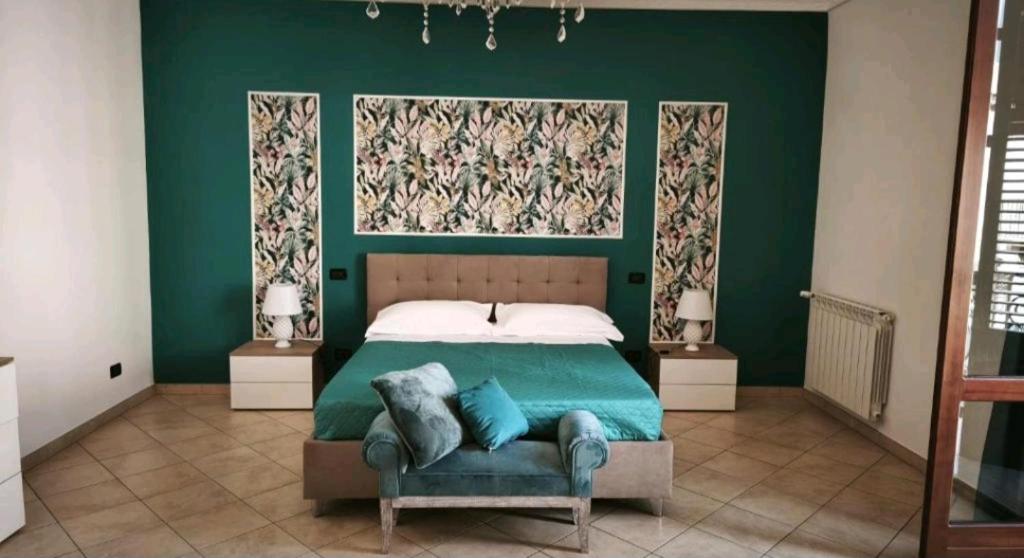 a green bedroom with a bed with a green wall at Nerissa apartments in Terrasini