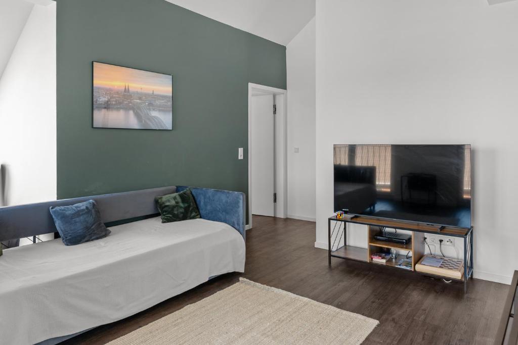 a living room with a couch and a flat screen tv at Loftbude in Hürth