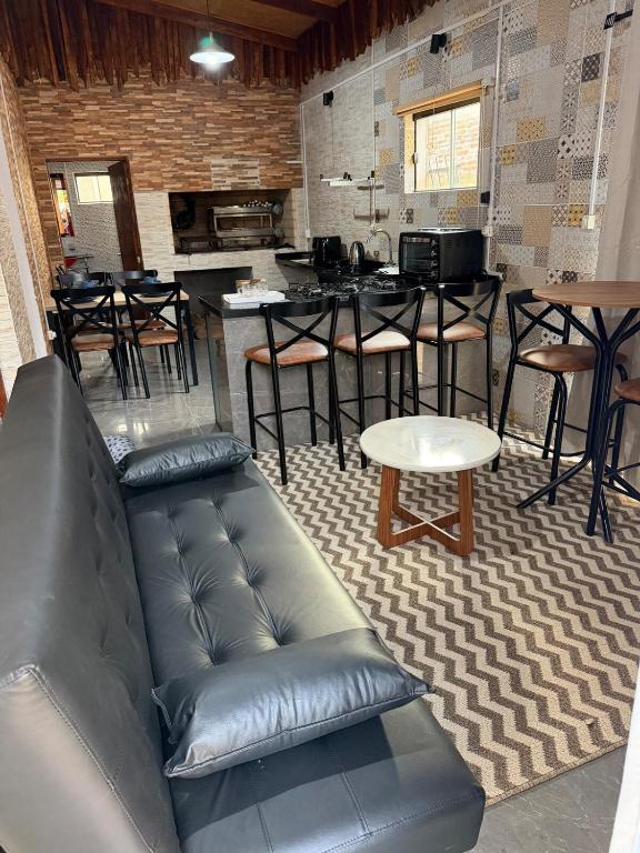 a living room with a leather couch and a bar at Casa Versatil in Chuí