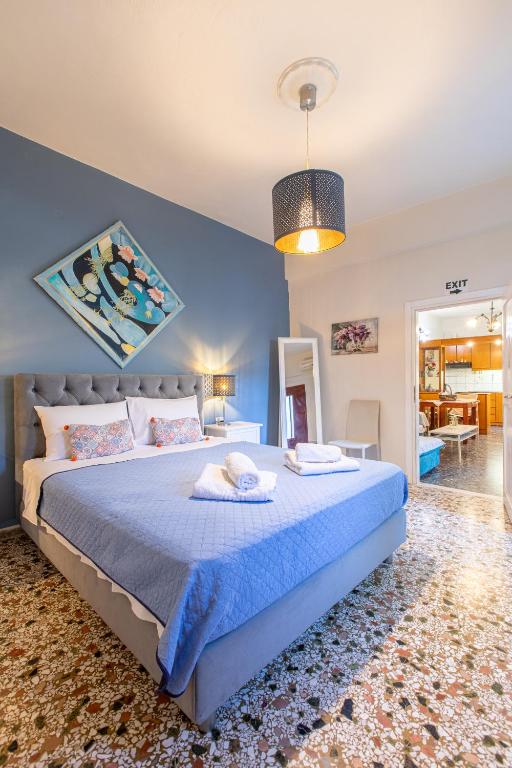 a bedroom with a large bed with a blue wall at House Klimataria Kamilari in Kamilari