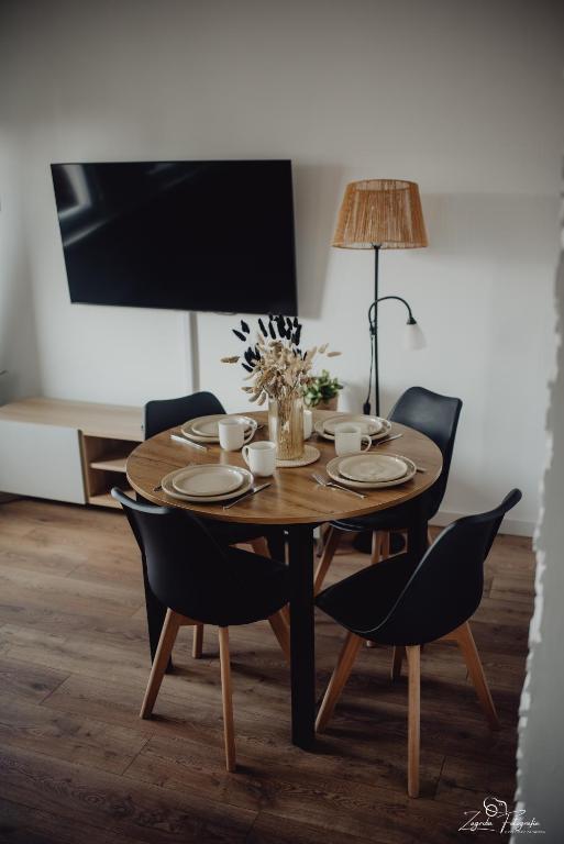 a dining room table with chairs and a lamp at Mazurska przystań in Ryn