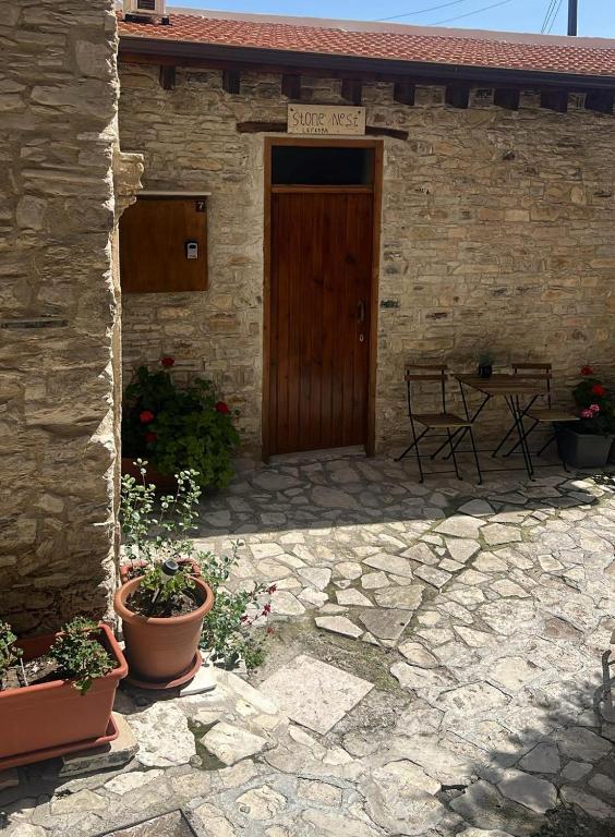 a stone building with a wooden door and a table at lefkara stone nest in Pano Lefkara