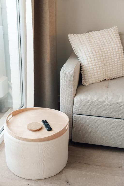 a remote control sitting on a ottoman next to a couch at Luxurious Suite - Train Station Deinze in Deinze