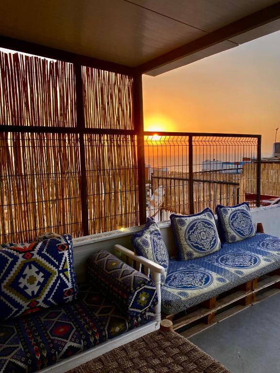 a couch sitting on a balcony with pillows on it at Titryte Hostel - chill rooftop in Aourir