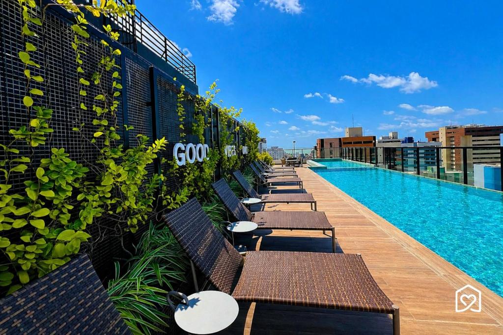 a row of benches on the side of a building with a swimming pool at Edifício MOVE Novo- Tambaú in João Pessoa