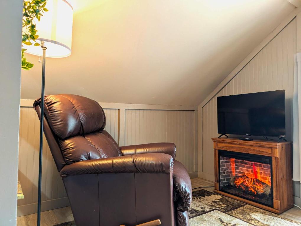 a brown leather chair in a living room with a fireplace at Studio Loft #9 at Riverside Point Resort in Park Rapids