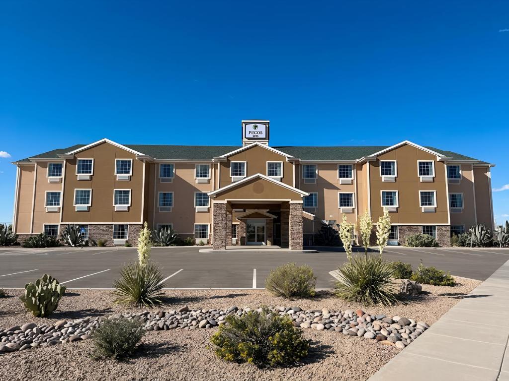 a large building with a parking lot in front at Garner Hotel Pecos by IHG in Pecos