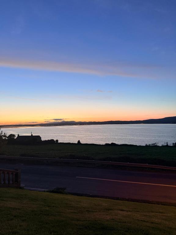 a sunset over a body of water with a road at Oceanview B&B in Ringville