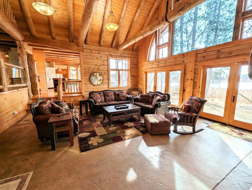 a living room filled with furniture in a wooden cabin at Fish Hook River Log Home with Theater & Dock in Park Rapids