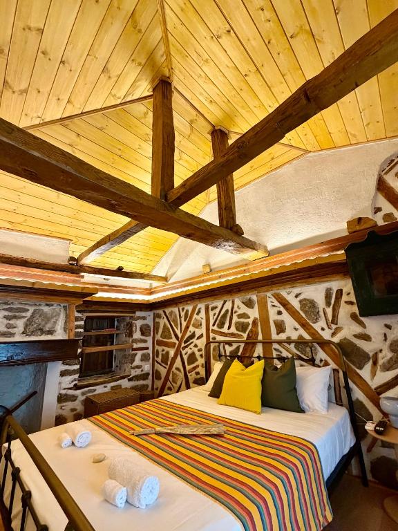 a bed in a room with a wooden ceiling at Atelies View House in Potamiá