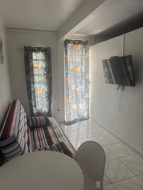 ein Wohnzimmer mit Fernseher, Sofa und Sesseln in der Unterkunft SCi 3I in Cayenne