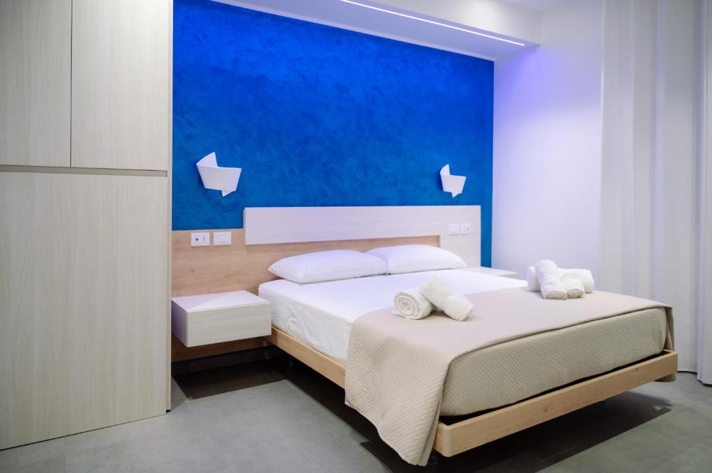 a bedroom with two beds with a blue wall at Orizzonte Blu in Villa San Giovanni