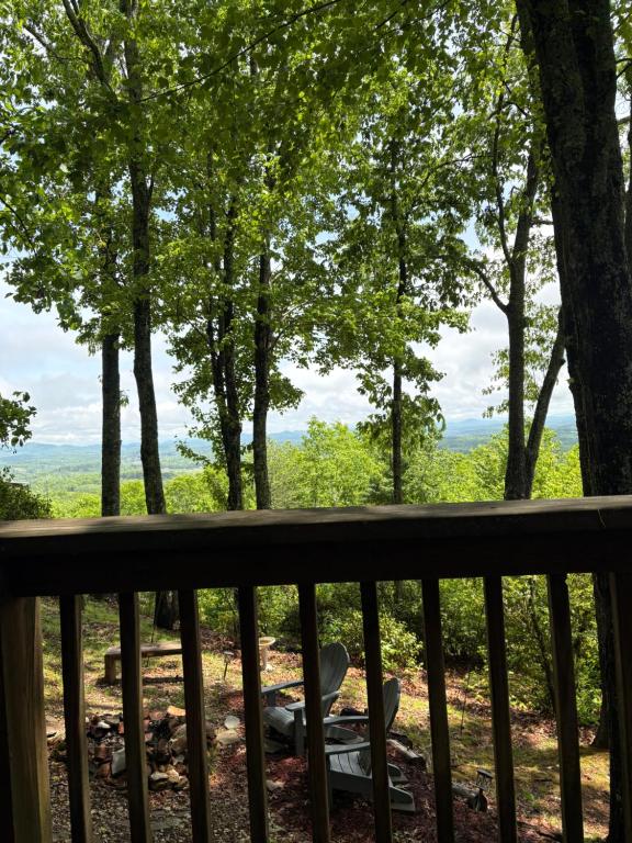 a view from the deck of a cabin with trees at Mae’s Cottage in the Clouds in Blue Ridge