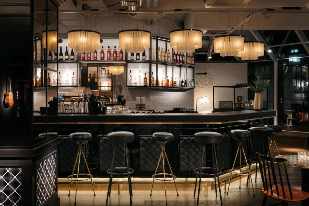a bar with bar stools in a room at Ruby Coco Hotel Dusseldorf by IHG in Düsseldorf