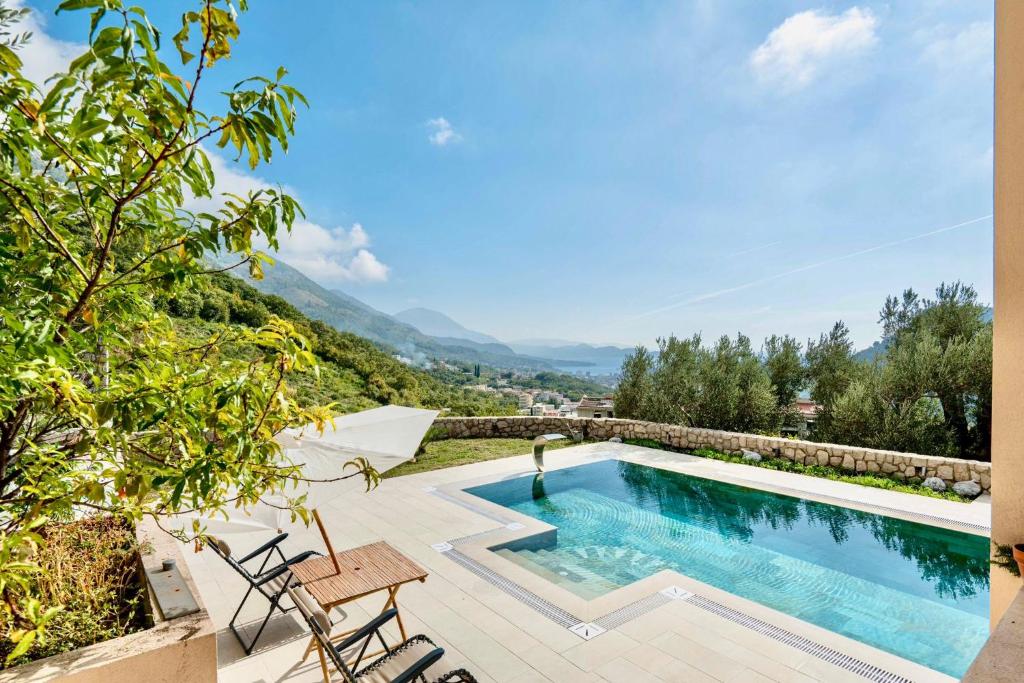 a swimming pool on a patio with mountains in the background at La Dolce Rustica - Hillside Villa in Sutomore