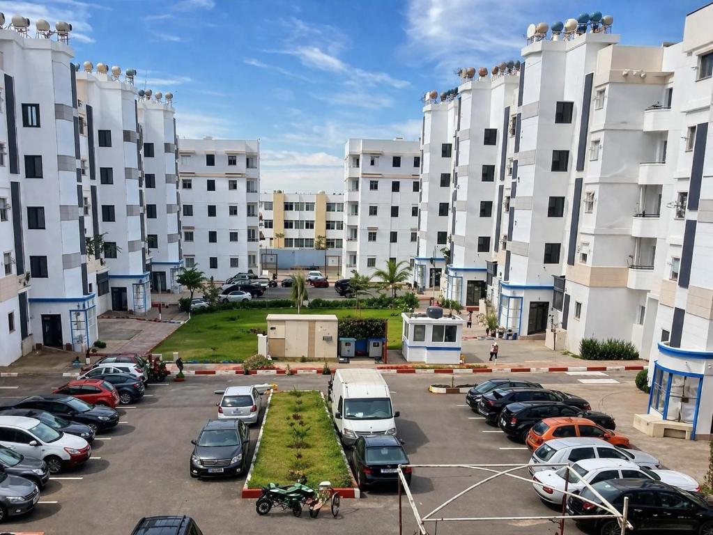 a parking lot with cars parked in front of tall buildings at Spacious 2BR Apartment with Moroccan Salon near Aquaparc Tamaris Casablanca in Casablanca