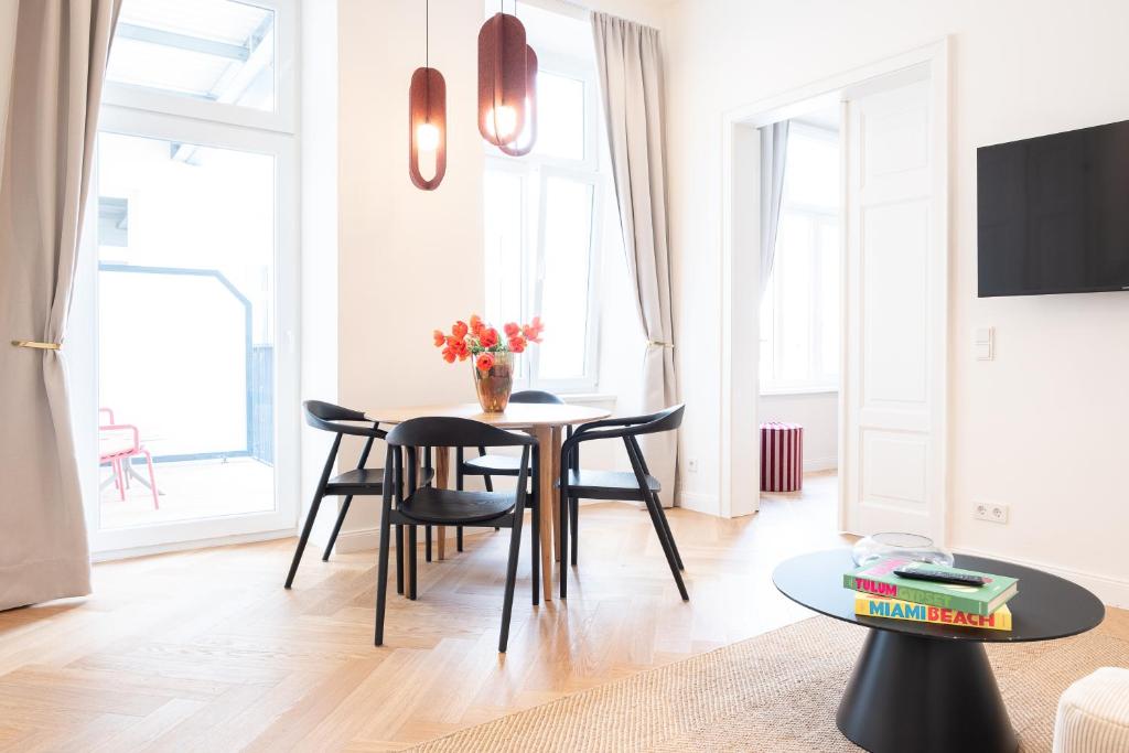 a dining room with a table and chairs in a living room at MINTNaschmarkt in Vienna