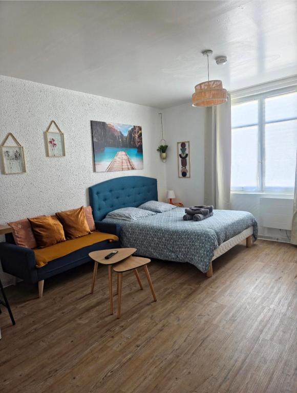 a bedroom with a blue bed and a couch at Studio - Le Bourgogne 21 in Orléans
