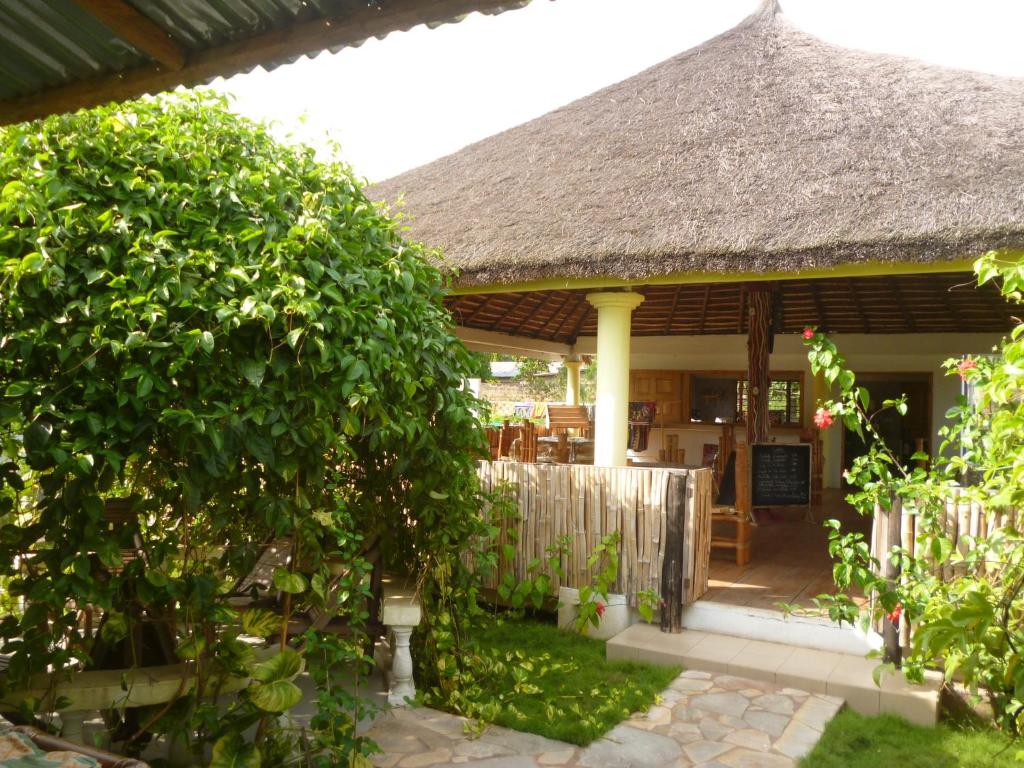 a house with a thatched roof and a garden at La Paillotte in Palimé