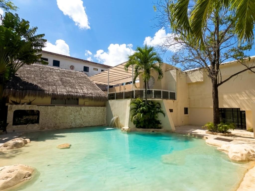 a swimming pool in front of a house at Hotel Xbalamqué Boutique & Spa in Cancún