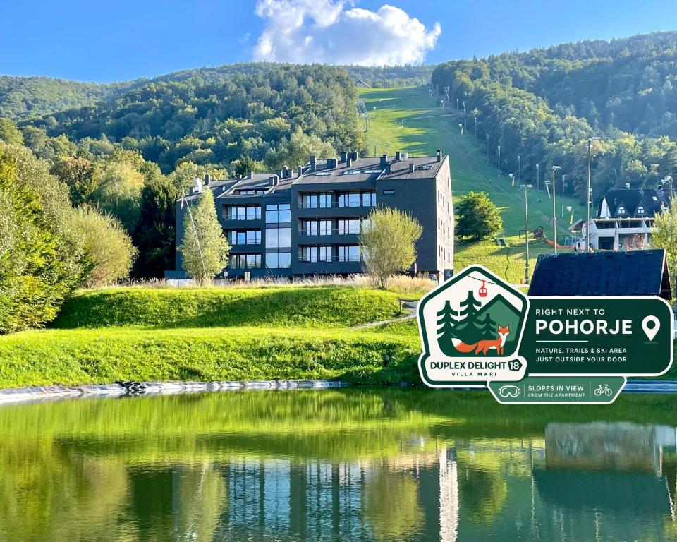 a hotel with a sign in front of a lake at Duplex Delight 18 Vila Mari in Pekre